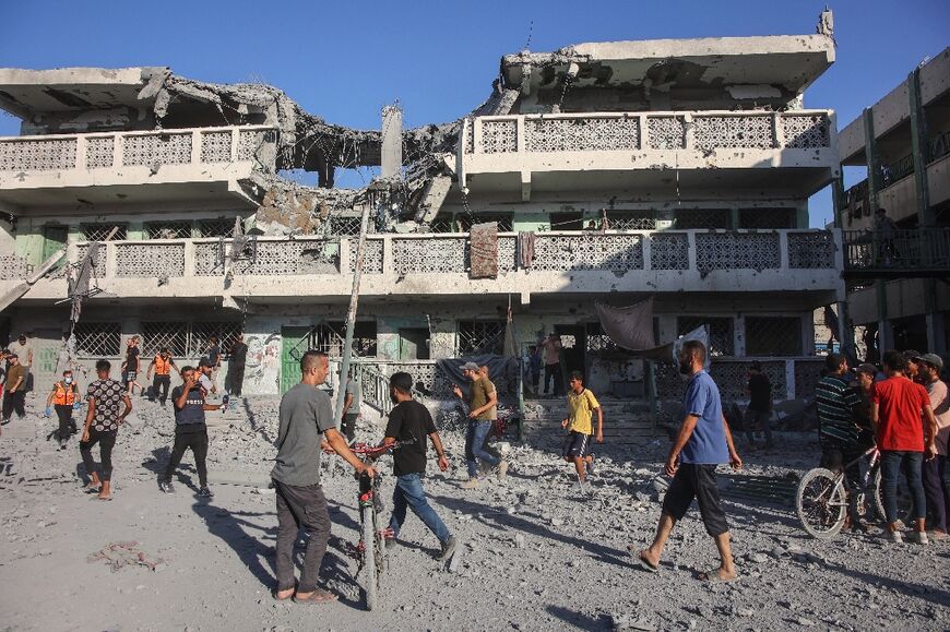 Palestinians inspect the rubble following Israeli bombardment of a school complex in Gaza City, on Saturday