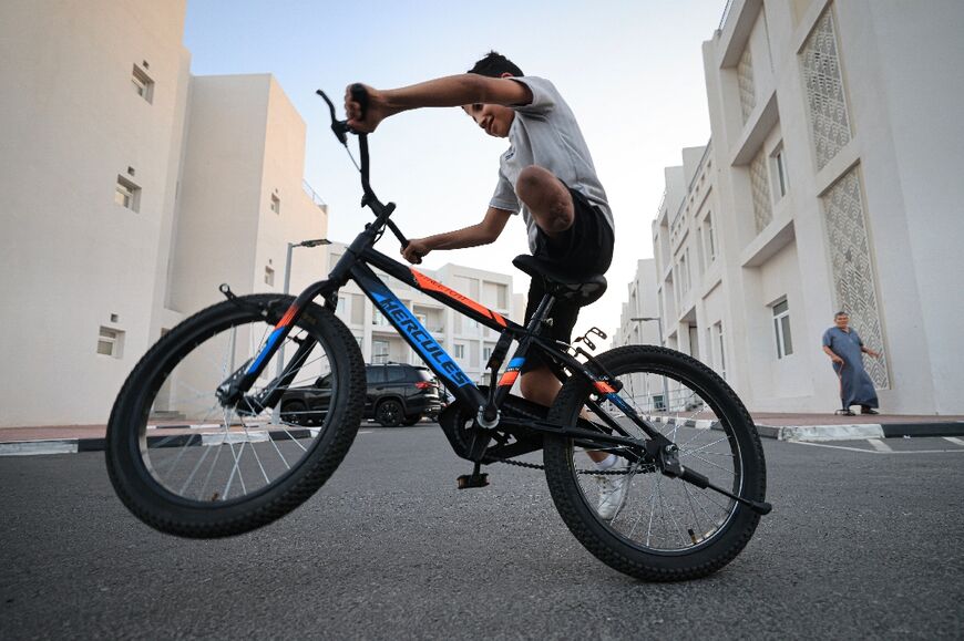 Karim al-Shayyah, 10, rides his bike around the complex despite losing his left leg