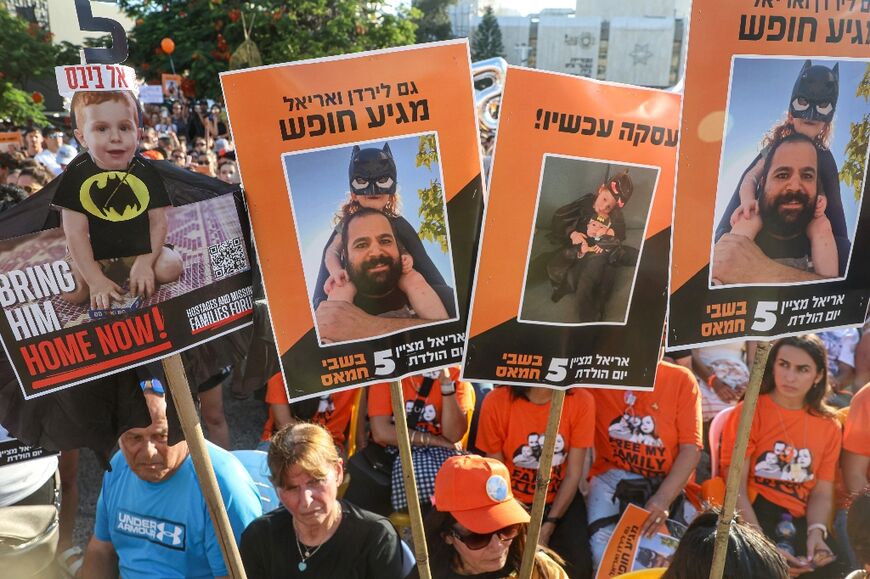 Participants lift placards and pictures during a gathering in Tel Aviv to mark the fifth birthday of Ariel Bibas, held hostage in Gaza, and to call for the liberation of him and his family