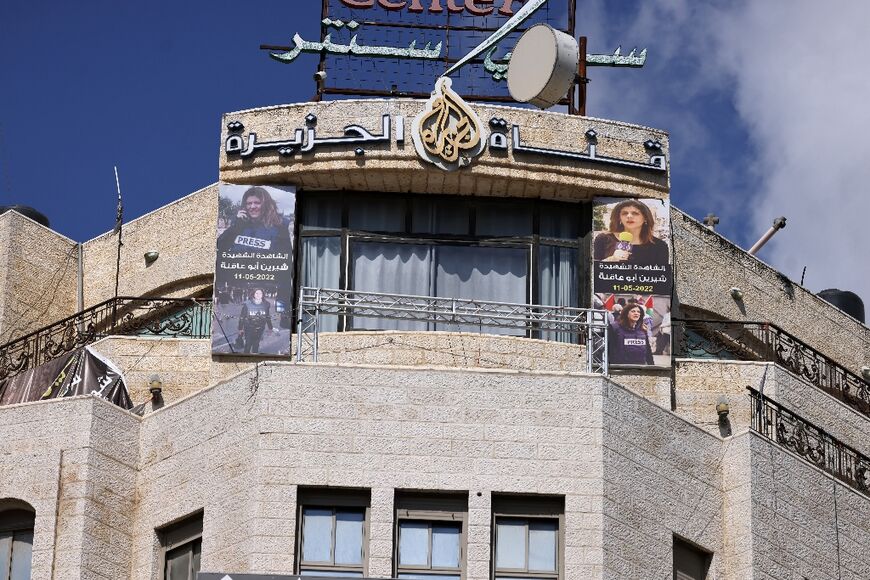 Pictures of slain Al Jazeera journalist Shireen Abu Akleh hang on the channel's office in Ramallah, in the occupied West Bank, which an Israeli court ordered shut for 45 days