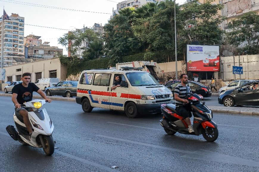 A Lebanese Red Cross ambulance rushes wounded people to hospital in Beirut after explosions hit Hezbollah strongholds around the country