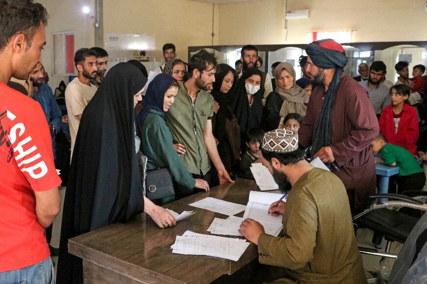 Afghan officials check the documents of refugees after their deportation from Iran, at a registration centre near the Afghanistan-Iran border in the Islam Qala district of Herat province