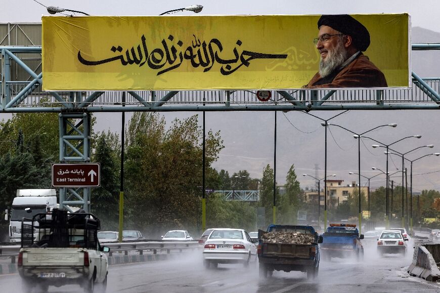 A picture of Hezbollah leader Hassan Nasrallah reads in Farsi, 'Hezbollah is alive', in northern Tehran before the Lebanese movement confirmed his death, which Israel said occurred in a strike on Beirut