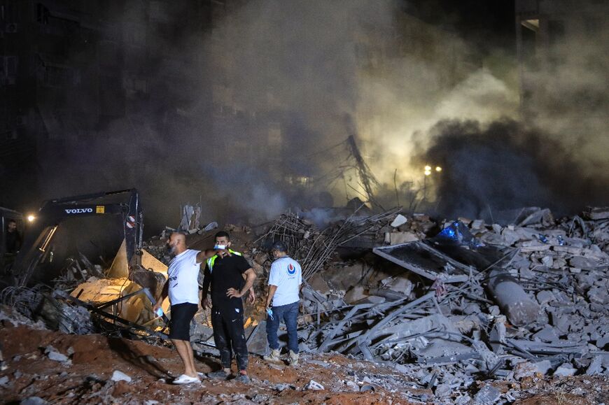 Rescuers inspect the rubble of a building destroyed in the Israel strike on Beirut's southern suburbs