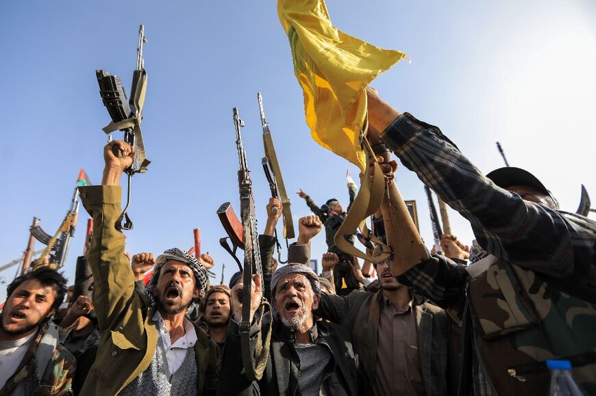 Protesters in the Huthi-controlled Yemeni capital brandish rifles and Hezbollah flags