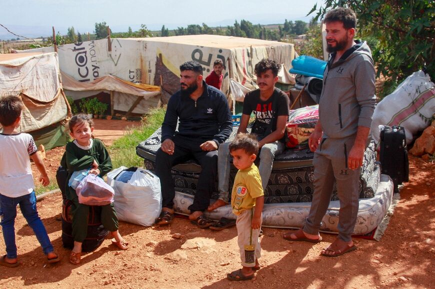 Syrians gather their belongings before leaving the southern Lebanese village of Wazzani after the leaflet drop