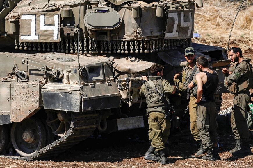 Israeli soldiers next to an armoured vehicle in the Upper Galilee region