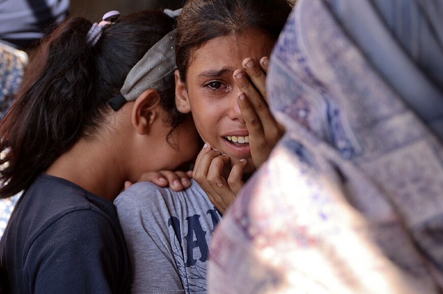 Children react following an Israeli strike on a school sheltering displaced Palestinians in Gaza