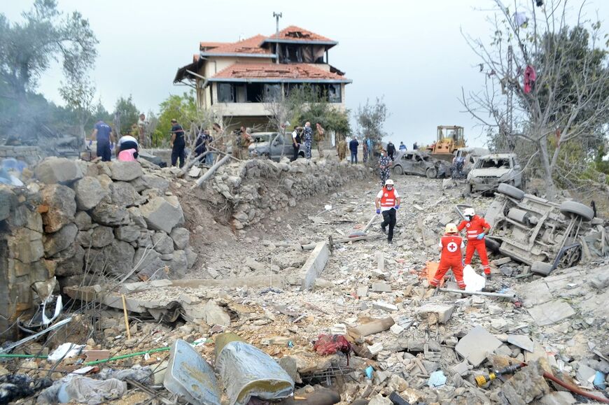 Red Cross paramedics unearth a body at the site of an Israeli air strike that targeted the northern Lebanese village of Aito