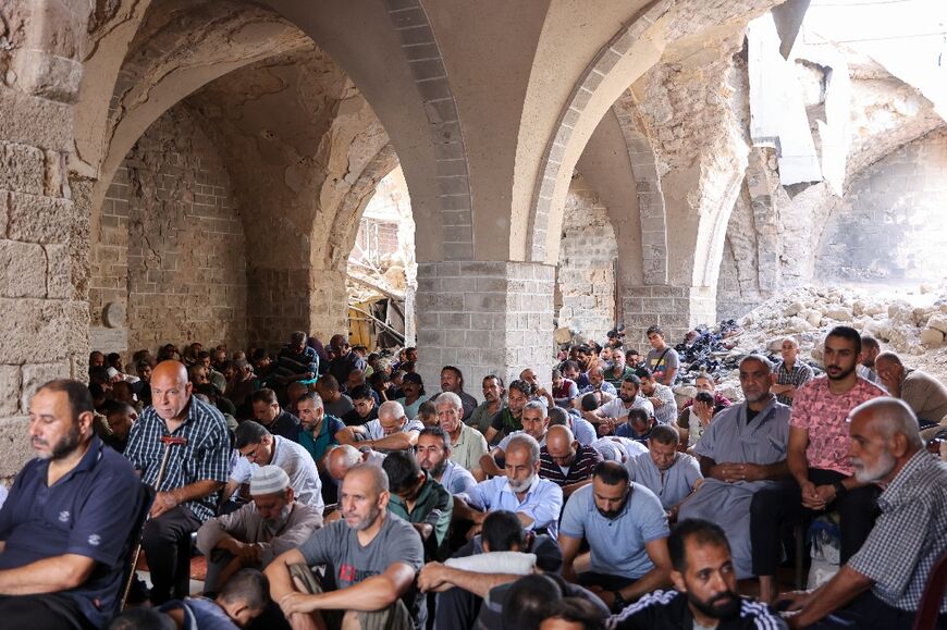 People attend Friday prayers in the damaged 13th-century Great Omari Mosque in the old town of Gaza City