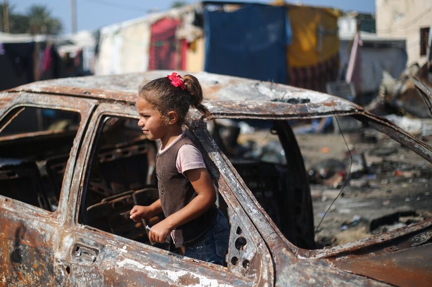 A girl in the ruins of a car in Gaza, where the US has called for more aid to be delivered