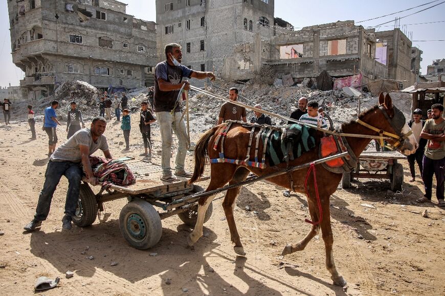 A man drives a horse-drawn cart carrying the body of a victim of an Israeli bombardment in the Zarqa neighbourhood in the north of Gaza City 