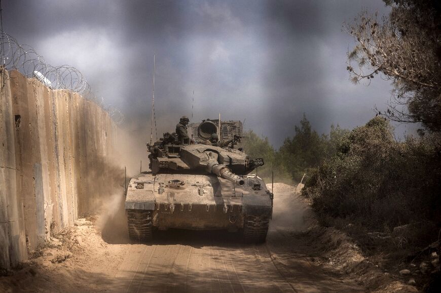 A photo taken during a controlled tour with the Israeli army shows an Israeli battle tank enters Lebanon from northern Israel at the southern Lebanese border point of Naqura