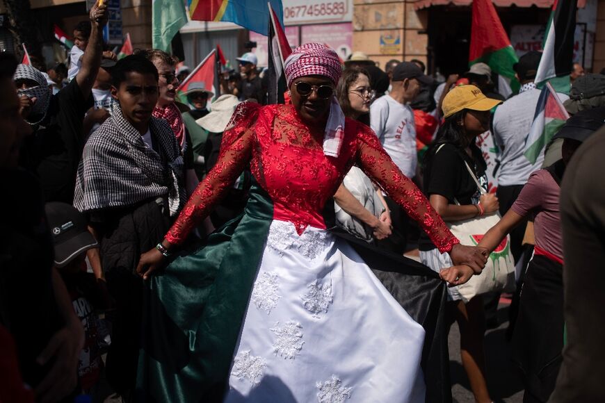 A woman wears a dress in the colours of the Palestinian flag as she takes part in a pro-Palestinian march in Cape Town