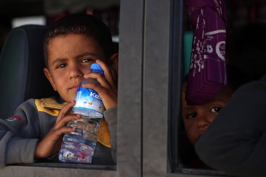 Children in a bus taking Syrians who were refugees in Lebanon back to their home country, as the war expands