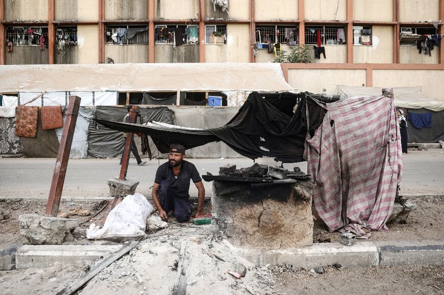 A Palestinian man bakes bread at a makeshift displacement camp in the central Gaza Strip