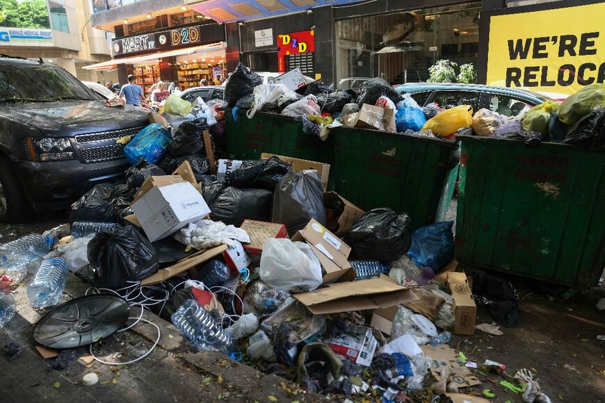 Garbage piles up on around bins on a roadside in Beirut