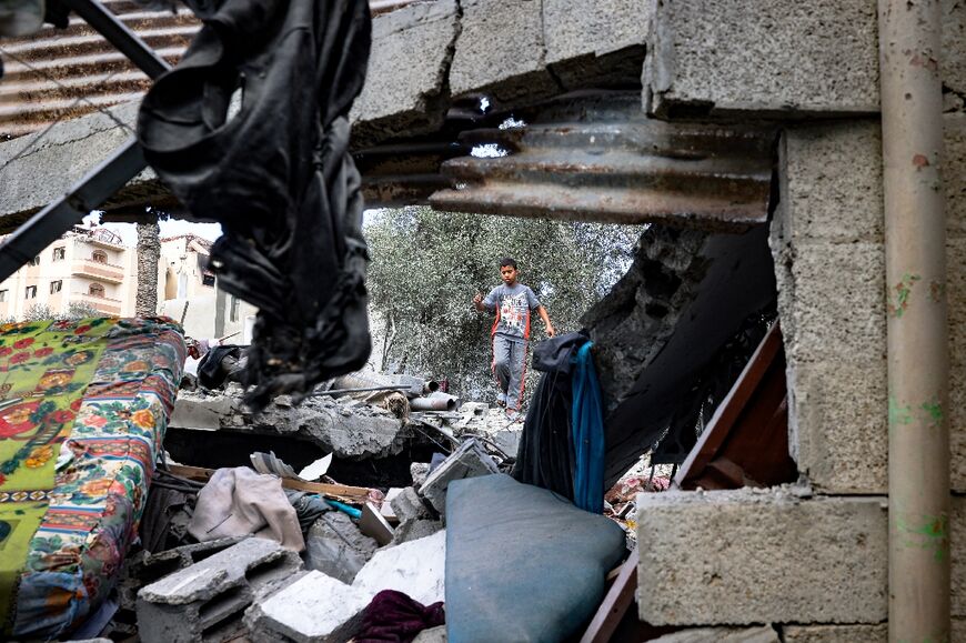 A boy walks amid the rubble of a house hit by an Israeli strike in central Gaza