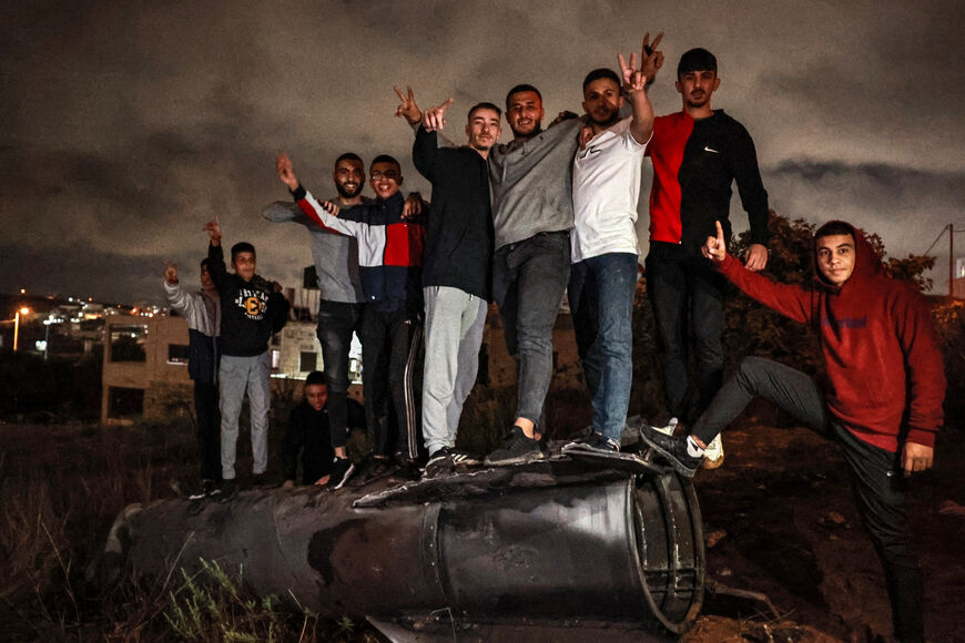 Palestinian youths celebrate as they stand atop a fallen projectile after Iran launched a barrage of missiles at Israel in response to the killings of Lebanese Hezbollah leader Nasrallah and other Iran-backed militants, in Ramallah in the occupied West Bank on October 1, 2024. Reports said Iran fired between 150 and 200 missiles in the attack, the country's second on Israel after a missile and drone attack in April in response to a deadly Israeli air strike on the Iranian consulate in Damascus. (Photo by Za