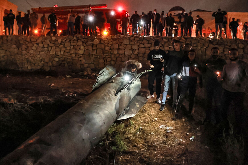 Palestinian youths inspect a fallen projectile after Iran launched a barrage of missiles at Israel in response to the killings of Lebanese Hezbollah leader Nasrallah and other Iran-backed militants, in Ramallah in the occupied West Bank on October 1, 2024. Reports said Iran fired between 150 and 200 missiles in the attack, the country's second on Israel after a missile and drone attack in April in response to a deadly Israeli air strike on the Iranian consulate in Damascus. (Photo by Zain JAAFAR / AFP) (Pho