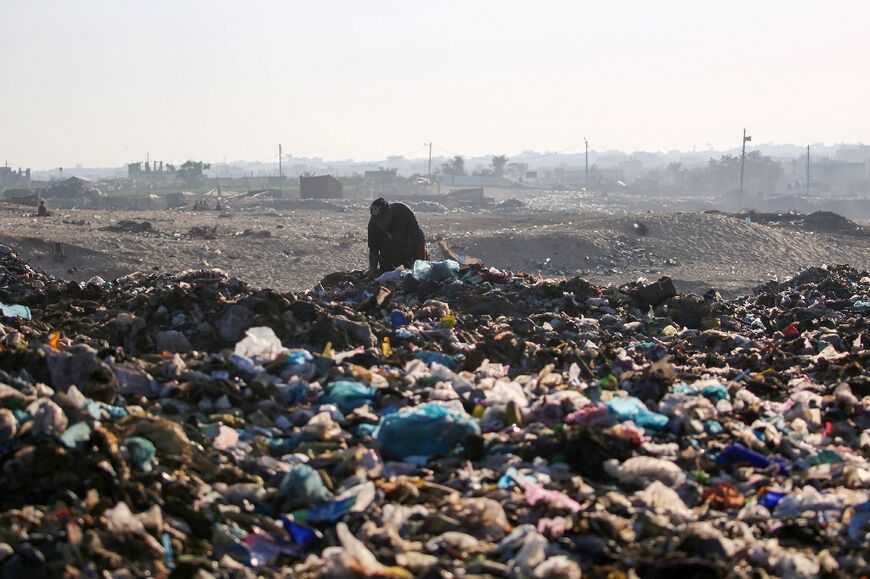 A Palestinian searches through a pile of garbage in Deir el-Balah, central Gaza 