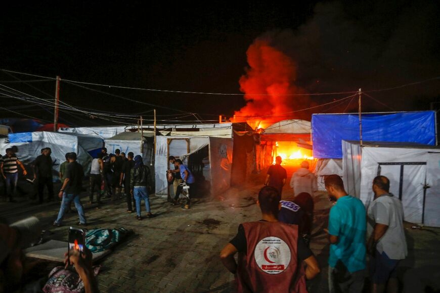 A picture provided by the United Nations agency for Palestinian refugees (UNRWA) shows the site of an Israeli air strike around tents for displaced people inside the walls of Al-Aqsa Martyrs Hospital in Deir El-Balah, central Gaza