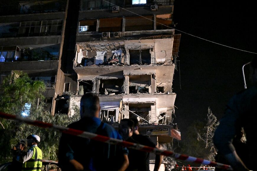 Three storeys of a residential building in Damascus were heavily damaged by what a war monitor said was an Israeli air strike targeting Hezbollah and its Iranian backers