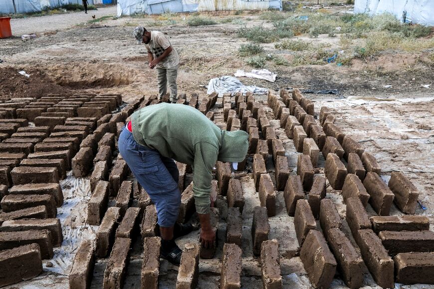 Men make mud bricks at the camp for displaced people near Hassan Shami village