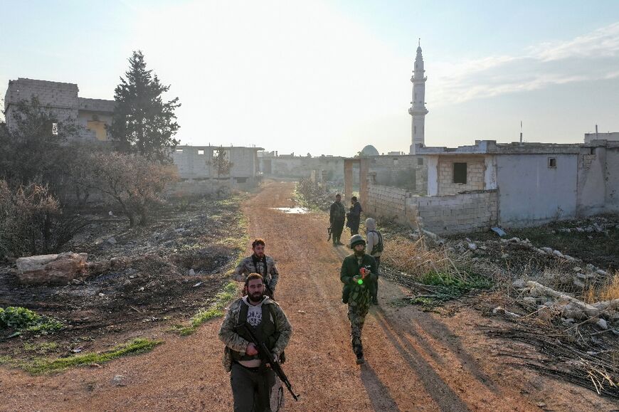 Fighters enter the village of Talhiyah, near the Taftanaz Syrian military airport, after jihadists and their Turkish-backed allies took over the area in battles with government forces