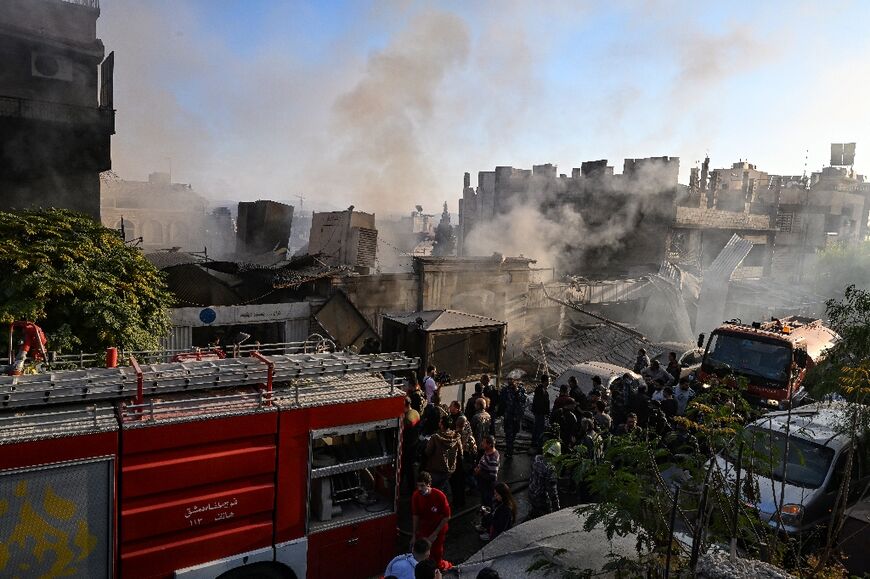 People check the damage following what a war monitor called an Israeli strike, that left Iran-backed fighters among the dead, in the Mazzeh district of Damascus 