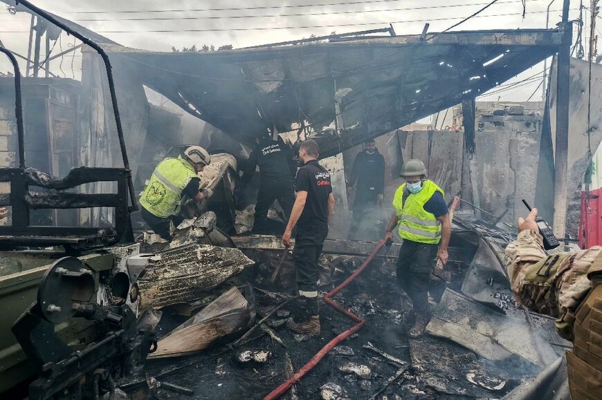 Rescuers douse the flames at the scene of an Israeli airstrike that hit a Lebanese army post in southern Lebanon