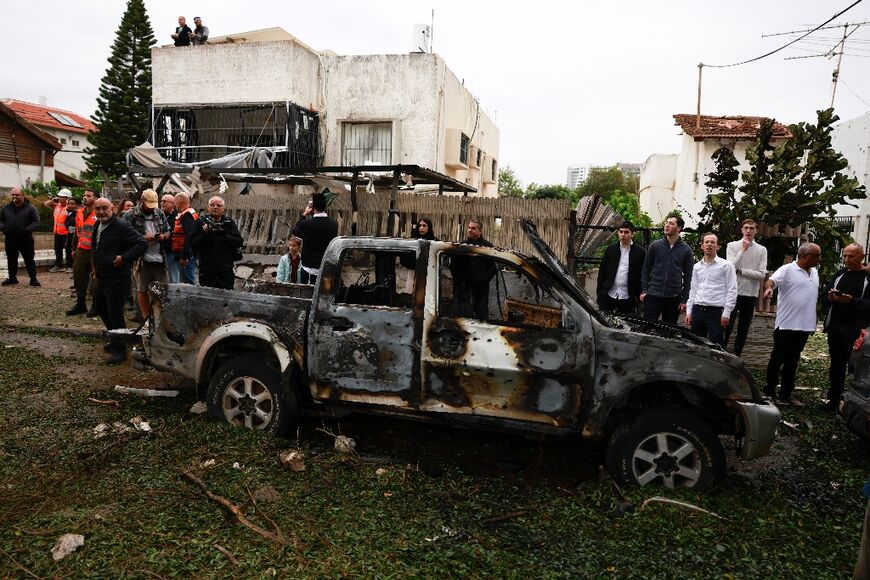 Rescuers and residents in central Israel's Petah Tikva, after rockets were fired from Lebanon