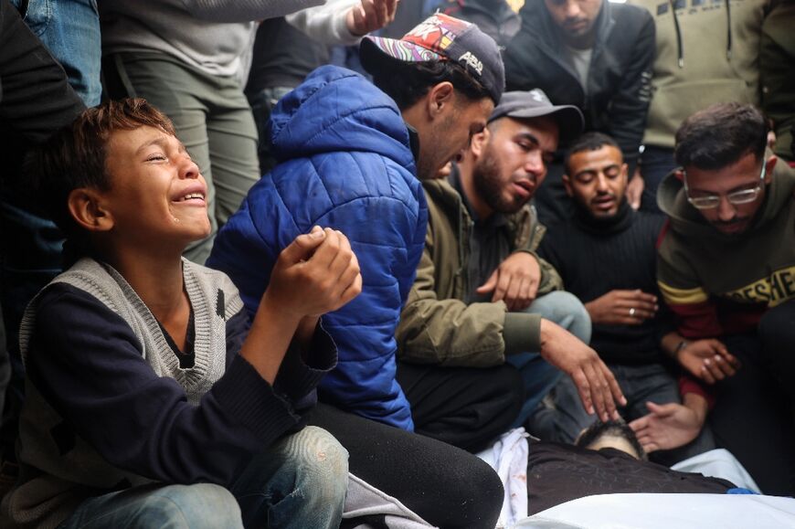 Relatives at Al-Aqsa Martyrs Hospital in Deir el-Balah, central Gaza, mourn over the bodies of Mahmud Fura and his son Saad Fura, killed during Israeli bombardment