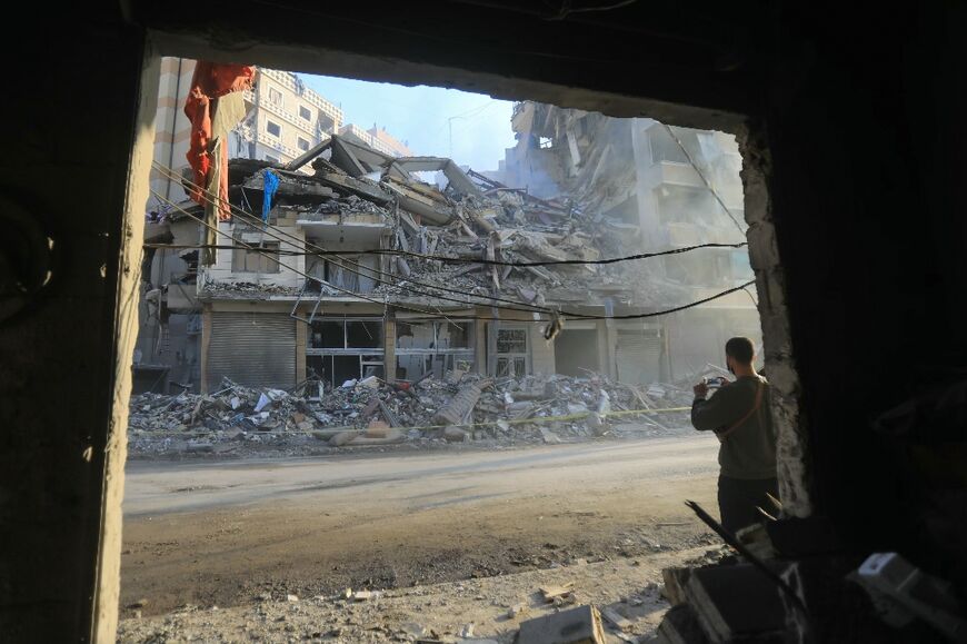 A man snaps a picture of a building hit by an Israeli strike, during a media tour organised by Hezbollah in Beirut's southern suburbs