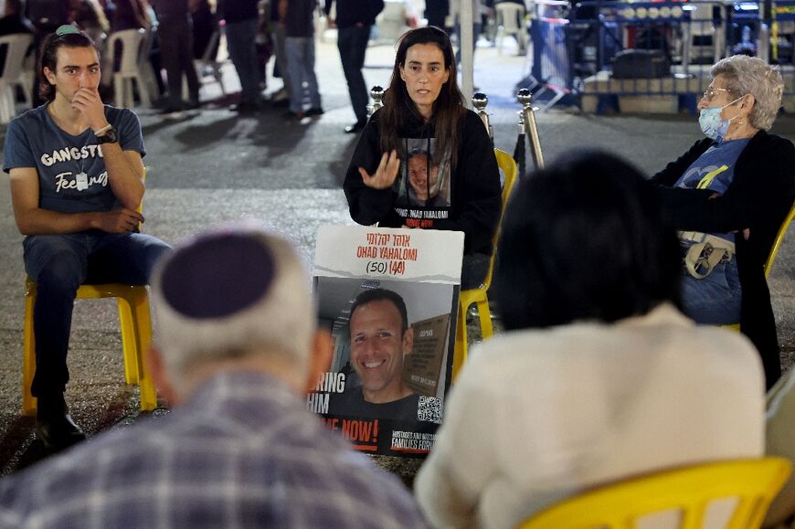 Before the main events on stage, the hostages' relatives and religious Jews gather in small talking circles