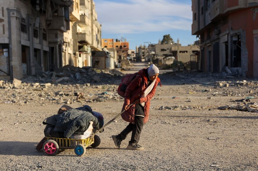 A displaced Palestinian woman flees Beit Lahia in the northern Gaza Strip