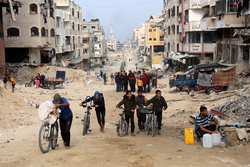 Palestinians move through a devastated street in Gaza City 