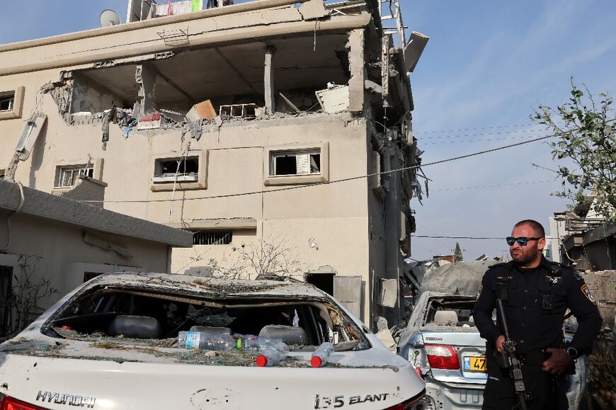 An Israeli police officer in the town of Tira checks damage following a rocket attack from southern Lebanon