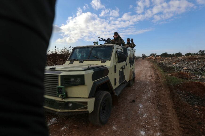 Fighters from Hayat Tahrir al-Sham (HTS) in the eastern outskirts of the town of Atarib, in Syria's Aleppo province where fighting has escalated