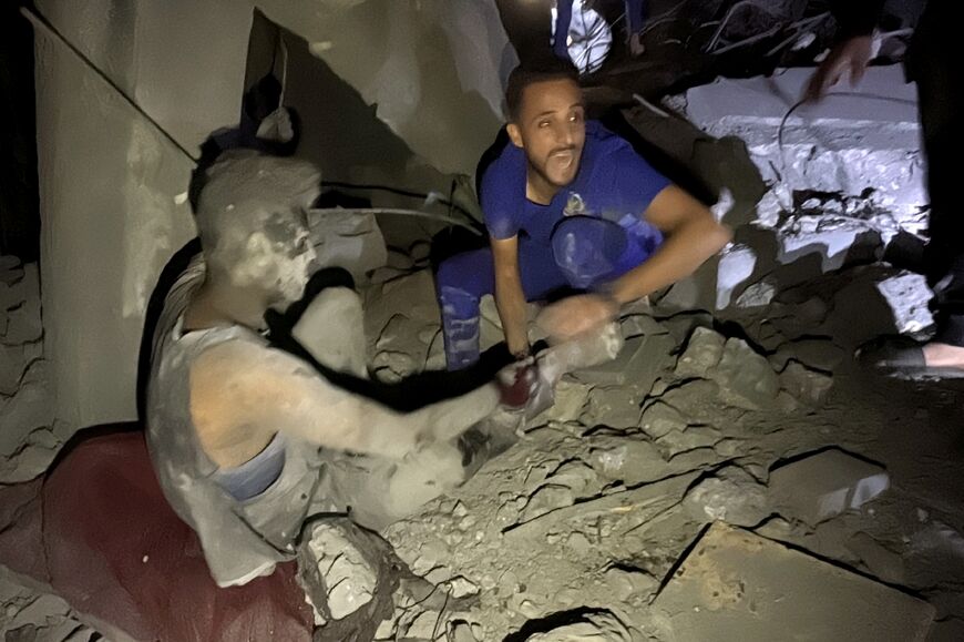 A man shouts as he pulls a survivor from the rubble of a building following an Israeli strike near Kamal Adwan Jospital in Beit Lahia, northern Gaza