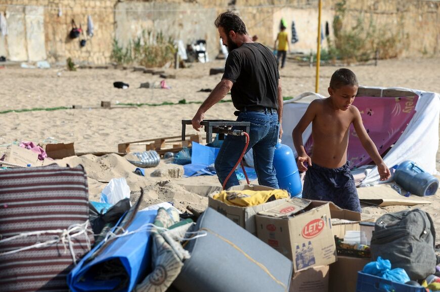 Displaced people who had taken refuge on Beirut's Ramlet al-Baida beach, gather their belongings 