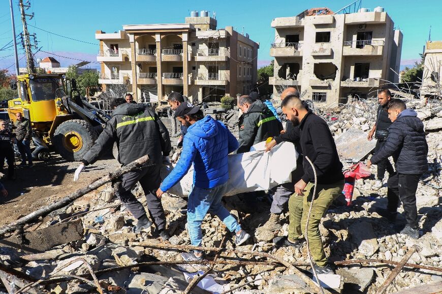 Rescuers evacuate the body of one of 14 of their colleagues killed in the rescue centre strike