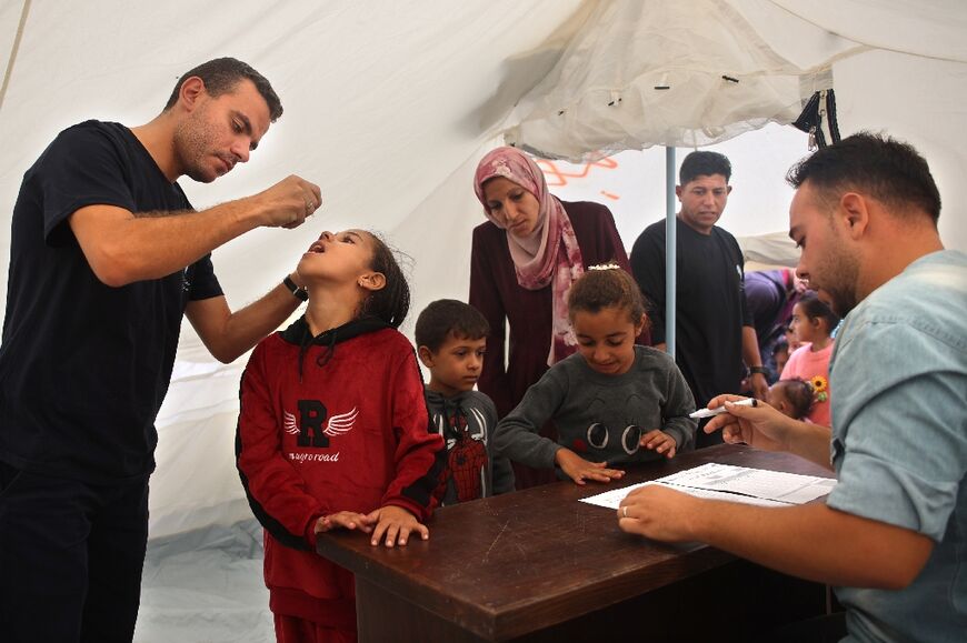 A medic administers polio vaccine to a Palestinian child at Abdel Aziz Rantissi hospital in the Gaza City area of north Gaza -- the campaign resumed after a halt due to Israeli bombing