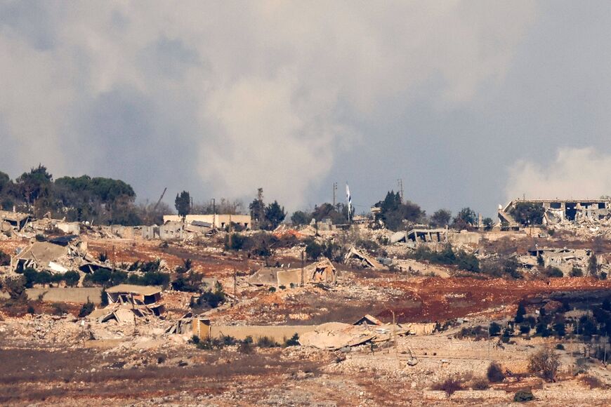 An Israeli flag amid damaged and destroyed buildings in the southern Lebanese village of Maroun al-Ras