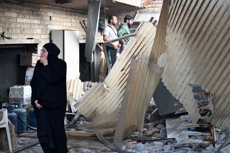 A woman reacts to the damage in Mazzeh, which has also seen previous strikes blamed on Israel