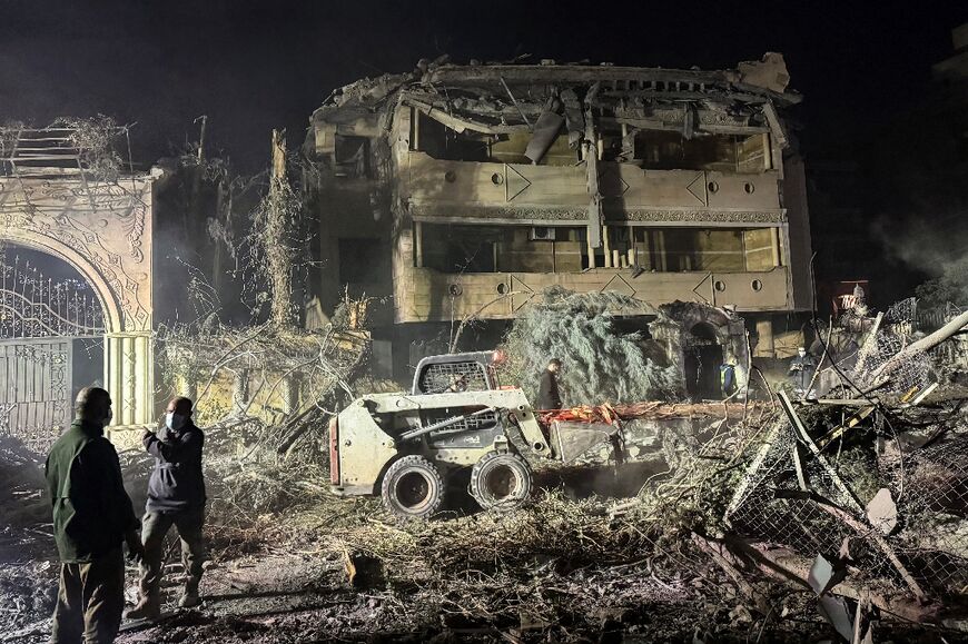 Workers remove the rubble from the site of the Israeli strike in the Beirut suburb of Shiyah.