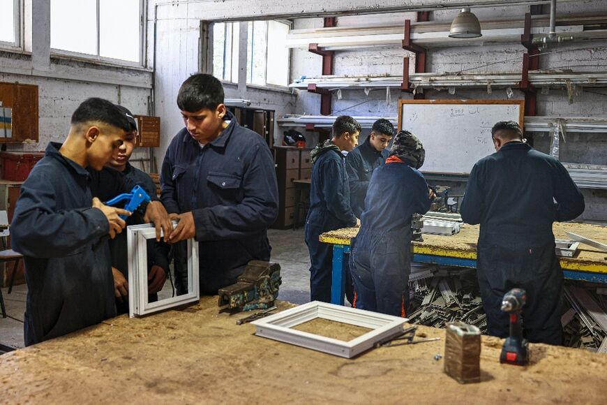 Plumbers in training assemble pipes, future electricians wire circuits and carpenters hammer together roofs at a UNRWA training centre