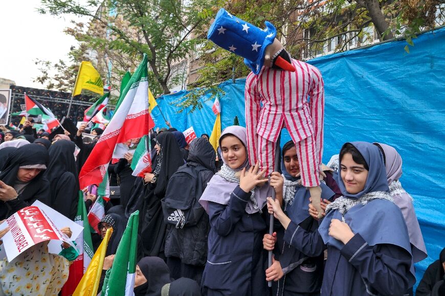 Women hold an Uncle Sam effigy during a rally outside the former US embassy in Tehran