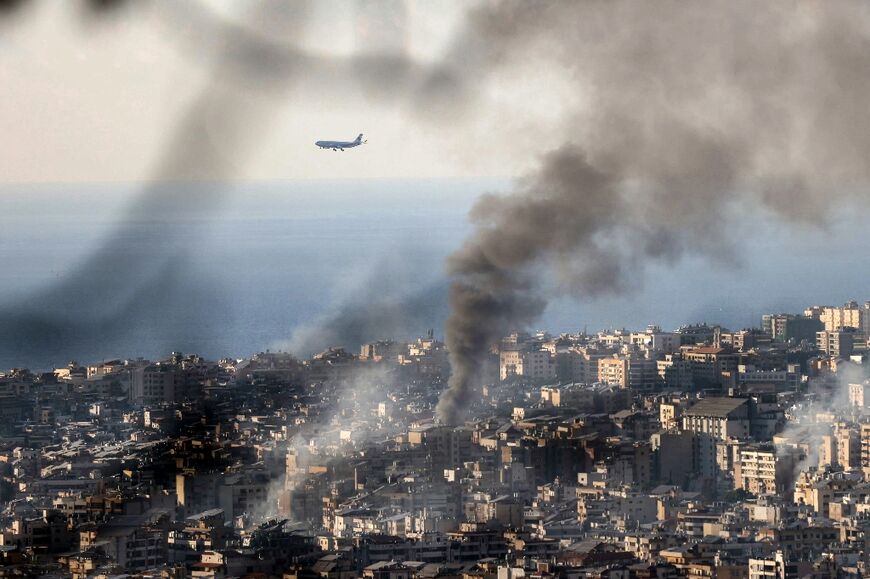 A Middle East Airlines plane approaches Beirut airport, as smoke rises from the site of an Israeli strike that hit the southern suburbs of the Lebanese capital, on November 16, 2024