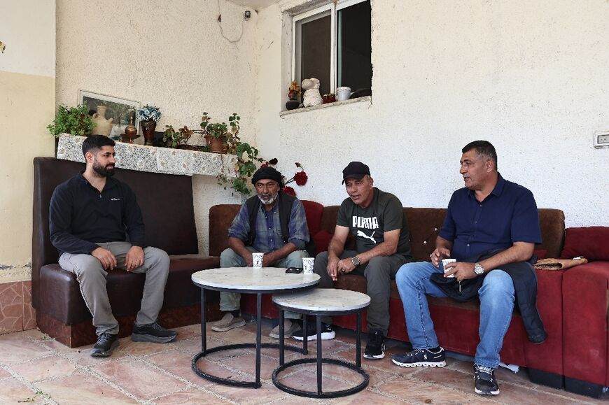 Odeh Juma (R), a California resident, and his son Adam (L) receive guests in their home  in Turmus Aya -- both father and son say they won't vote in the US election